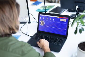 Caucasian businesswoman sitting at desk, using laptop with statistical data on screen