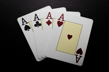 Four aces on a dark board
