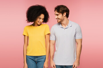 Fototapeta premium pretty latin woman and young man smiling while standing isolated on pink.