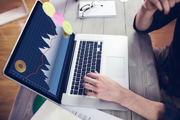 Hands of caucasian businessman sitting at desk, using laptop with statistical data on screen