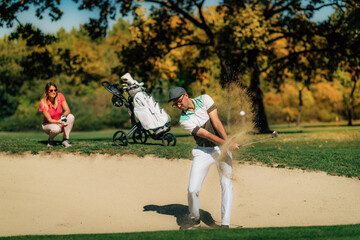Golfer playing from the sand trap