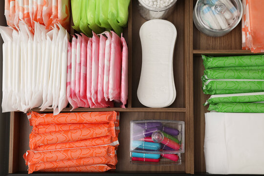 Storage of different feminine hygiene products in wooden organizers, top view