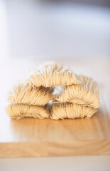 Dried noodle on a wooden cutting board, selective focus.