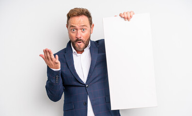 middle age handsome man amazed, shocked and astonished with an unbelievable surprise. copy space...