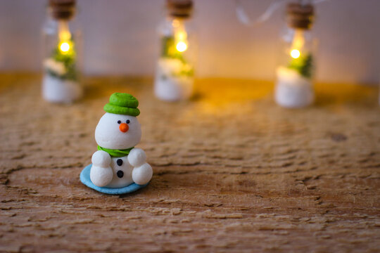 Christmas decor. Miniature powdered sugar snowman stands on a wooden board - Powered by Adobe