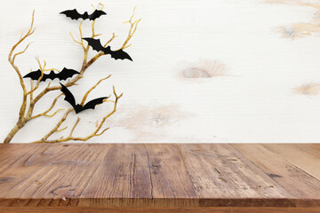 Halloween holiday concept. Empty rustic table in front of bare trees and bats background. Ready for product display montage