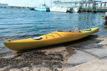 Fototapeta premium Modern kayak on beach near river. Summer camp activity