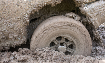 Car wheel stuck in mud, motorsport, mud tire testing. Off-road driving, car breakdown. Emergency evacuation.
