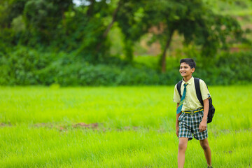 Indian school boy at green onion agriculture field.