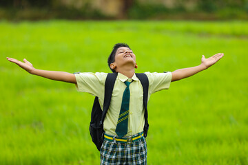 cute indian little school boy enjoying nature