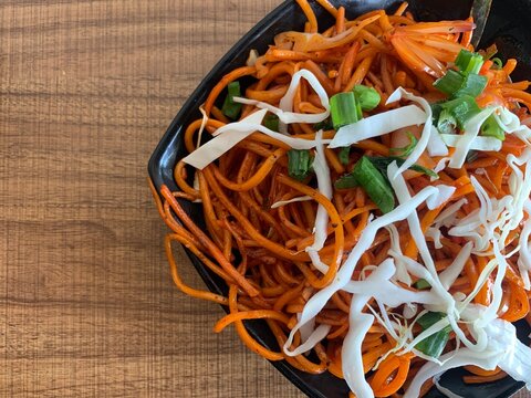 Vegetarian Schezwan Noodles or Vegetable Hakka Noodles or Chow Mein in bowl. Schezwan Noodles is indo-chinese cuisine hot dish with udon noodles, vegetables and chilli sauce
