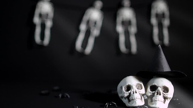 Two skull and the witch's hat. Skeletons in the background