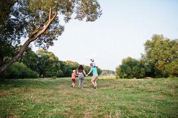 Happy young family: mother, father, two children son on nature having fun.