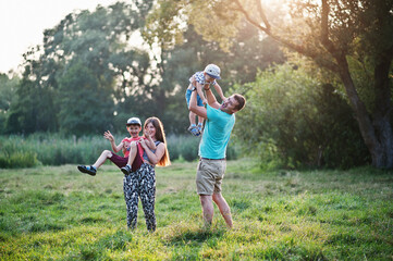 Happy young family: mother, father, two children son on nature having fun.