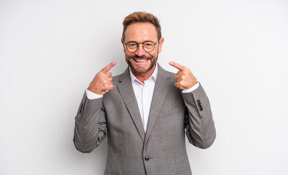 middle age handsome man smiling confidently pointing to own broad smile. businessman concept