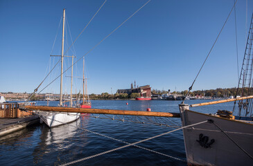 Fototapeta premium Water view at the bay Ladugårdsviken old sailboats and museums on the island Djurgården a colorful autumn day in Stockholm