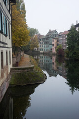 Fototapeta na wymiar view of autumnal trees in border the Il river at the little france quarter in Strasbourg
