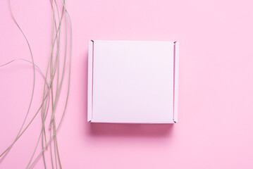 Pink cardboard box decorated with dried grass, mock up.
