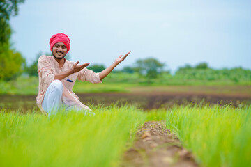 Young indian farmer at green onion agriculture field.