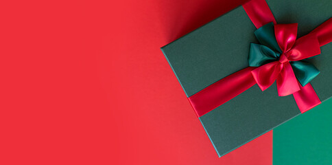 Present box for Christmas holiday on a green and red background. New Year's gift. Copy space for text, mock up, banner