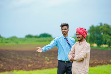 Indian farmer Discussing with agronomist at agriculture field and collecting some information