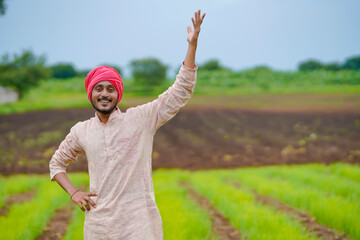 Young indian farmer at green onion agriculture field.