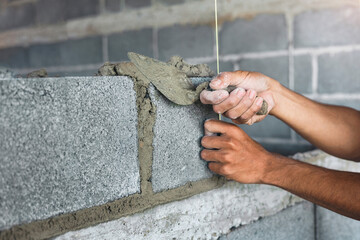 hand of worker plastering cement at wall for building house