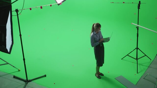 Beautiful Young Woman Wearing Casual Skirt and Shirt, Using Laptop Computer in Green Screen Mock Up Chroma Key Studio. Business, Corporate Office, Work, Technology Concept.