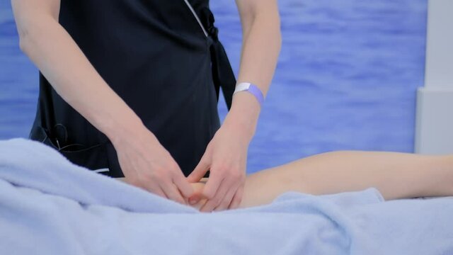 Professional female masseuse hands doing leg massage for woman client at spa salon, studio or exhibition - close up view. Wellness, relaxation, wellbeing, rehabilitation and healthcare concept