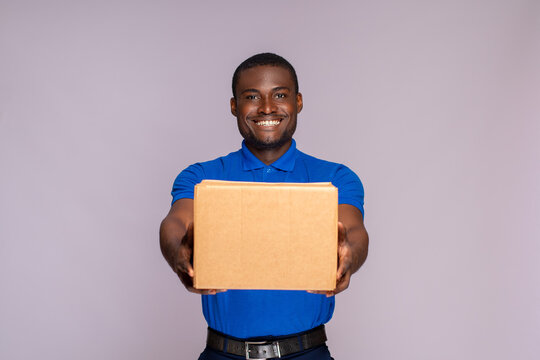 portrait of a black delivery worker holding forward a package