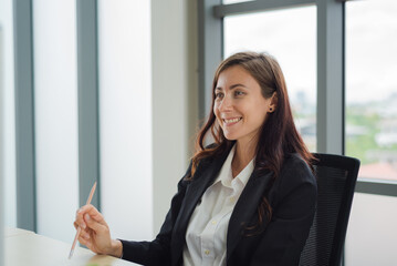 Smart business woman in formal suit outfit working about company task in front of computer with happy and smile in modern office workplace.