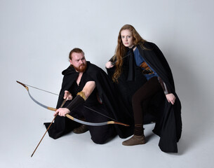 Full length  portrait of red haired  couple, man and woman wearing medieval viking inspired fantasy...