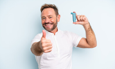 middle age handsome man feeling proud,smiling positively with thumbs up. asthma concept