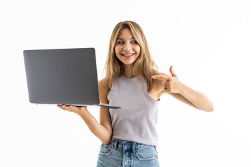 Naklejka premium Portrait of smiling woman holding and pointed laptop over white background