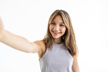 Young beautiful woman taking selfie. Isolated white background