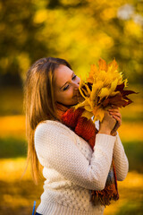 Cute smiley woman holding autumn maple leaves