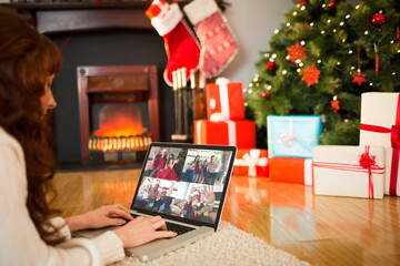 Caucasian woman on christmas tablet video call with diverse group of friends