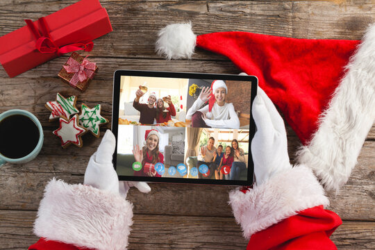 Santa claus on christmas laptop video call with diverse group of friends