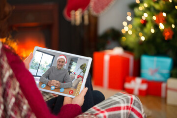 Caucasian woman on christmas tablet video call with caucasian man