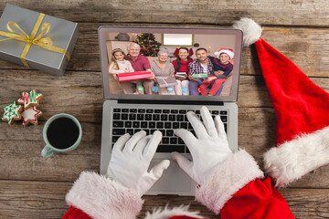 Santa claus on christmas laptop video call with caucasian family