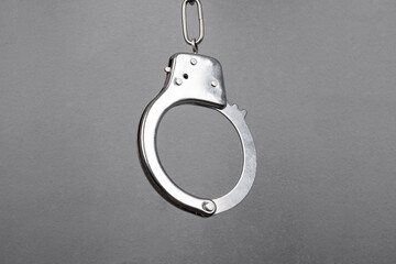 metal handcuffs on a gray wall background close-up