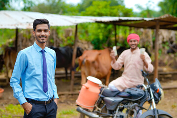 Indian farmer with agronomist at his cattle farm