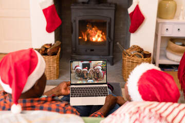 African american couple in santa hats on christmas video call with family