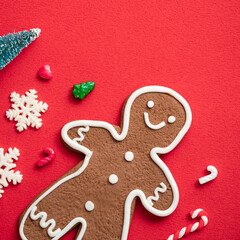 Decorated Christmas gingerbread cookies on red table background.