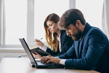 colleagues sitting in front of a laptop teamwork internet professionals