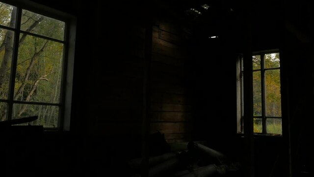 Dark view from old creepy spooky abandoned wooden house in countryside
