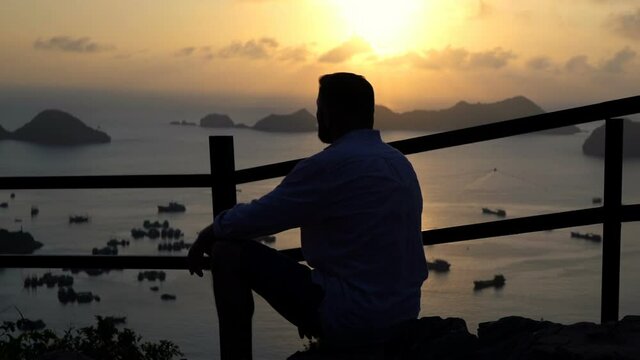 Man admire amazing sunset over Ha Long Bay in Vietnam