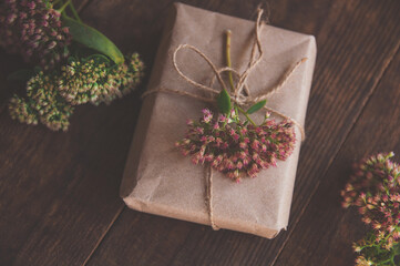 Homemade Gift box wrapped in kraft paper and pink flowers