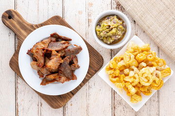 Nam Prik Num, Thai food, Northern Thai Green Chilli Dip with fried pork and crispy pork crackling on old white wood texture background, top view, flat lay