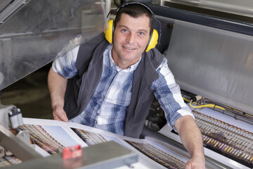 man working in printing factory printing press
